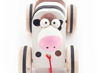 Cute wooden cow toy looking up, kids love her silly looks